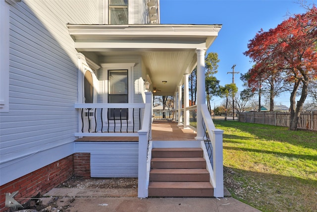 property entrance with covered porch and a lawn