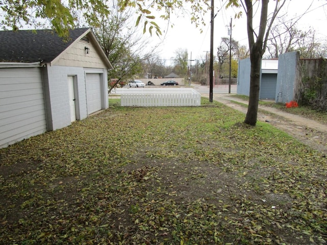 view of yard with a garage and an outbuilding