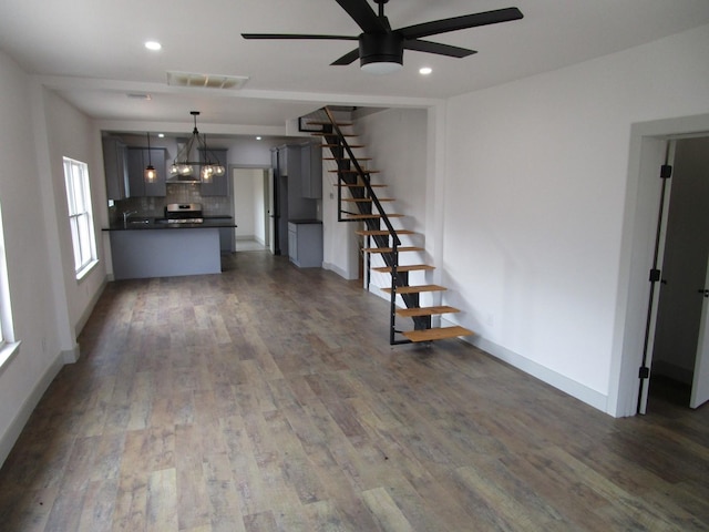 unfurnished living room featuring ceiling fan and dark hardwood / wood-style flooring