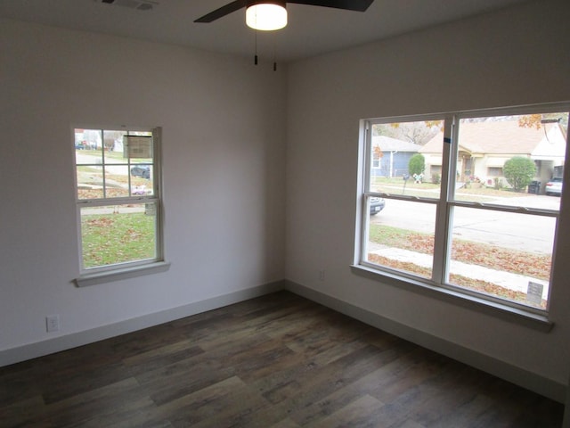 unfurnished room with dark wood-type flooring, ceiling fan, and a wealth of natural light