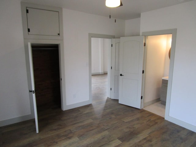 unfurnished bedroom featuring connected bathroom and dark wood-type flooring