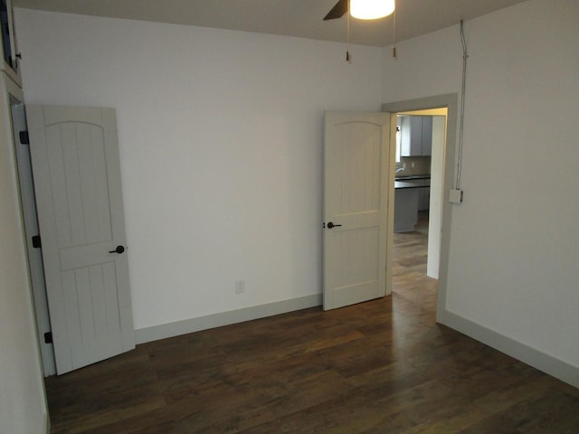 spare room featuring dark wood-type flooring and ceiling fan