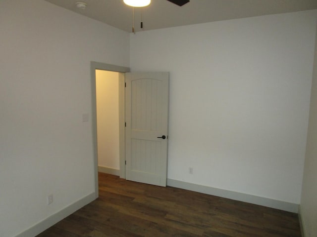 spare room featuring dark hardwood / wood-style flooring and ceiling fan