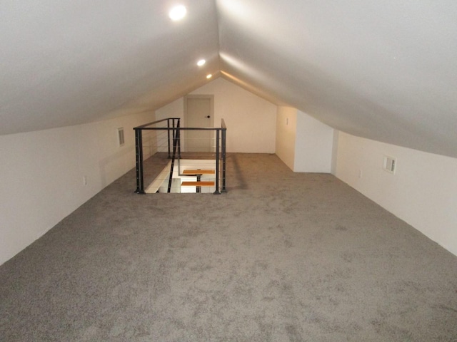 bonus room with lofted ceiling and carpet flooring