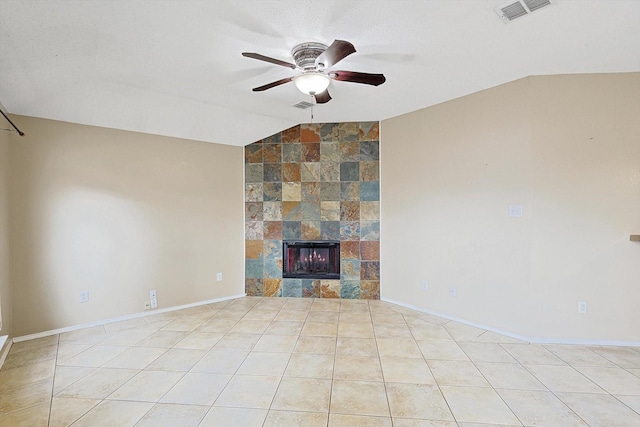 unfurnished living room featuring vaulted ceiling, ceiling fan, light tile patterned flooring, and a fireplace