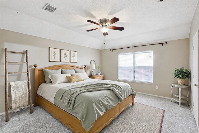 carpeted bedroom with ceiling fan and a textured ceiling