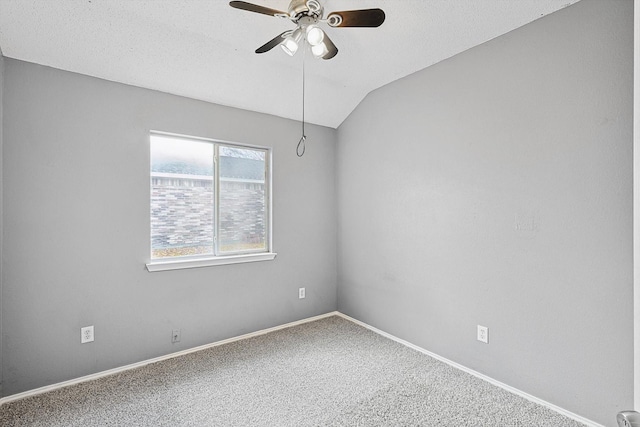 carpeted empty room featuring lofted ceiling, ceiling fan, and a textured ceiling