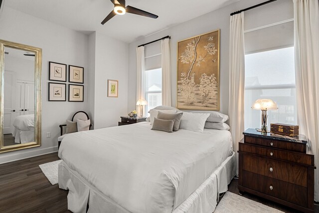 bedroom with dark hardwood / wood-style flooring and ceiling fan