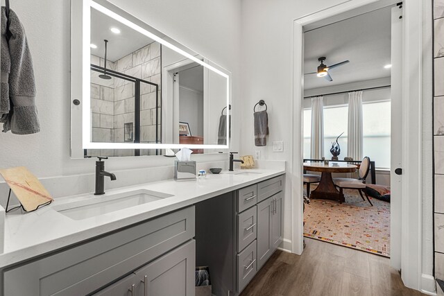 bathroom with ceiling fan, a shower with door, vanity, and wood-type flooring