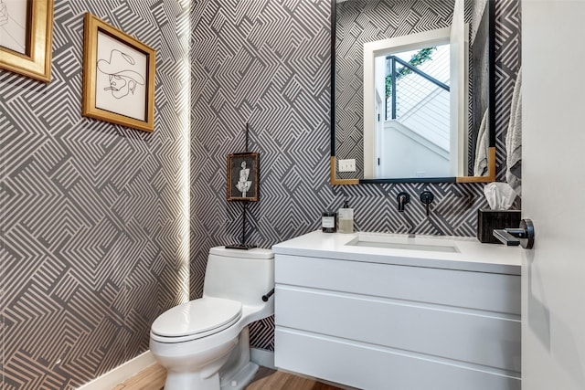 bathroom featuring toilet, hardwood / wood-style floors, and vanity