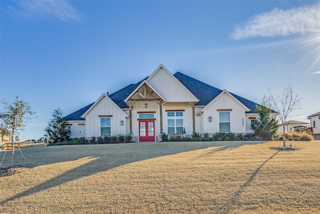 modern farmhouse style home with a front lawn and french doors