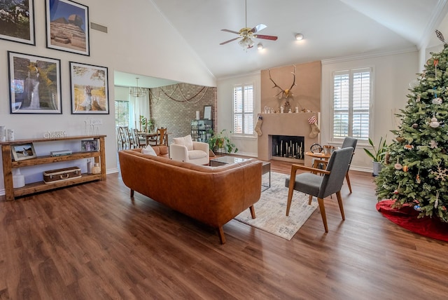 living room featuring crown molding, plenty of natural light, wood-type flooring, and a fireplace