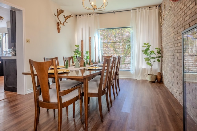 dining space featuring brick wall, a healthy amount of sunlight, and dark hardwood / wood-style floors