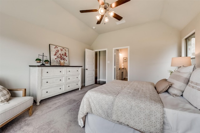 carpeted bedroom with ensuite bathroom, vaulted ceiling, and ceiling fan