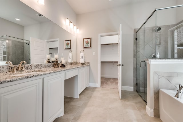 bathroom featuring tile patterned floors, plus walk in shower, and vanity