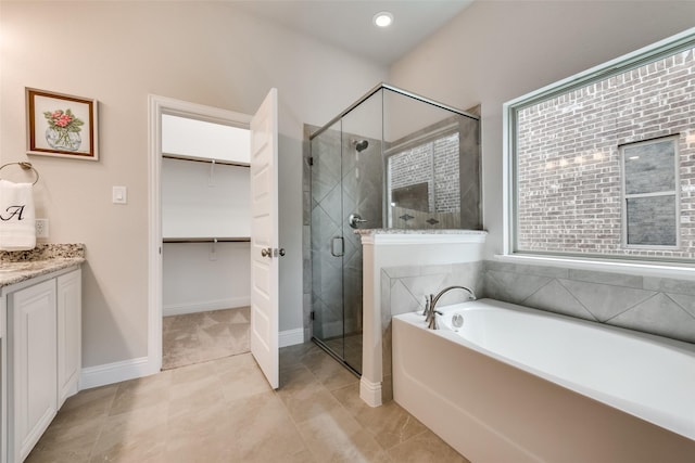 bathroom featuring tile patterned flooring, shower with separate bathtub, and vanity