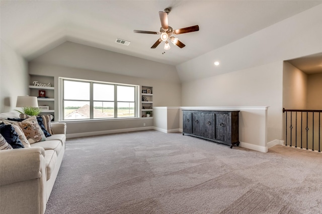 living room featuring built in shelves, light colored carpet, and vaulted ceiling