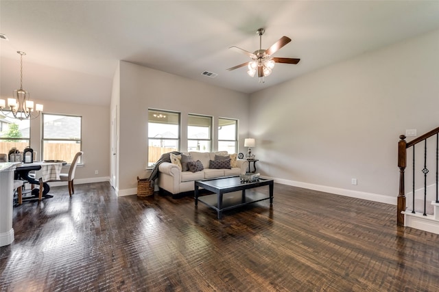 living room featuring ceiling fan with notable chandelier, dark wood-type flooring, and vaulted ceiling