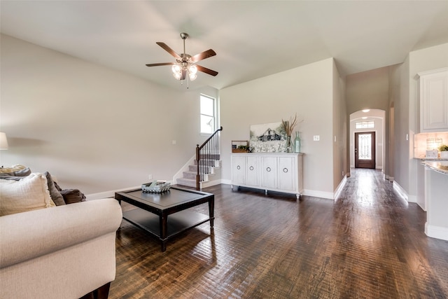 living room with ceiling fan and dark wood-type flooring