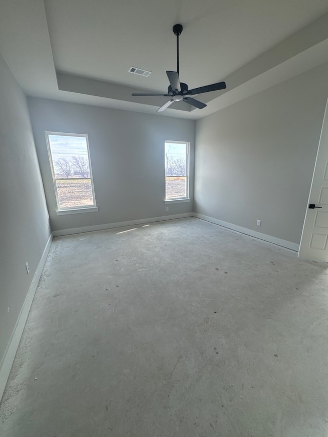 empty room with a tray ceiling and ceiling fan