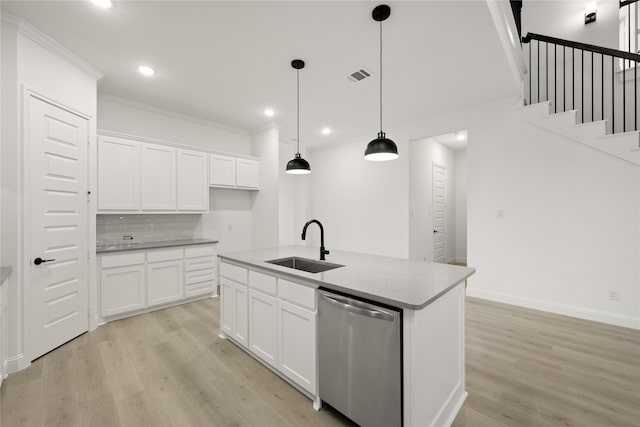 kitchen with white cabinetry, sink, hanging light fixtures, stainless steel dishwasher, and a center island with sink