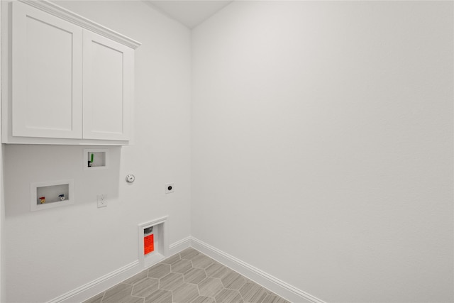 laundry room featuring gas dryer hookup, cabinets, hookup for an electric dryer, and hookup for a washing machine