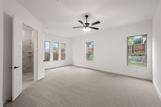 unfurnished bedroom featuring ceiling fan, light colored carpet, and connected bathroom