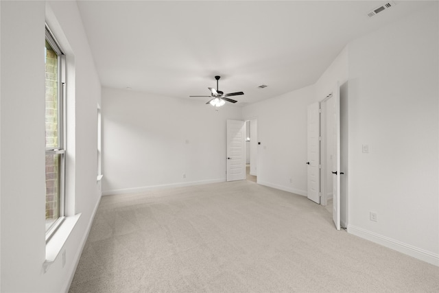 spare room featuring light carpet and ceiling fan