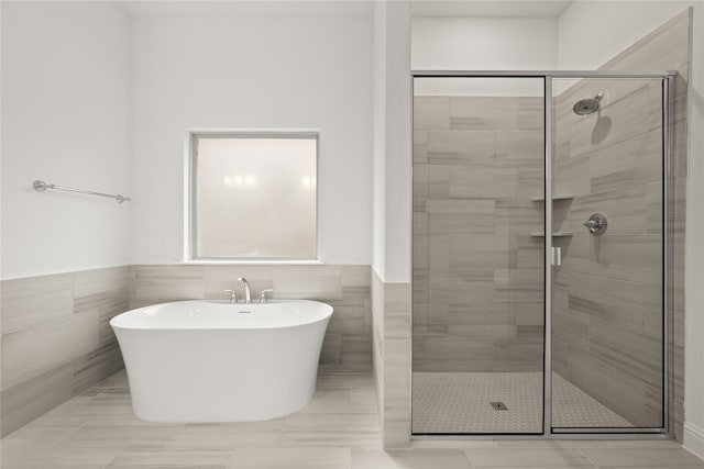 bathroom featuring independent shower and bath and tile walls