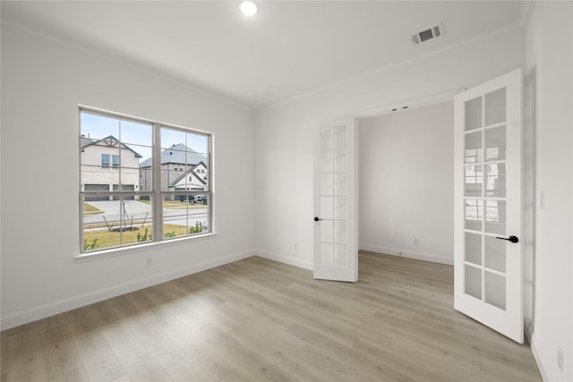 unfurnished room featuring ornamental molding, light hardwood / wood-style flooring, and french doors