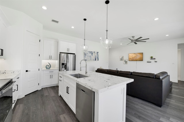 kitchen featuring dark wood-type flooring, a center island with sink, sink, appliances with stainless steel finishes, and white cabinetry