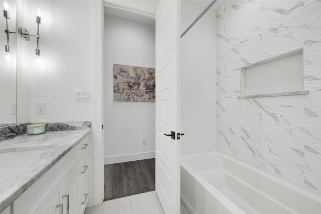 bathroom featuring vanity, wood-type flooring, and tiled shower / bath