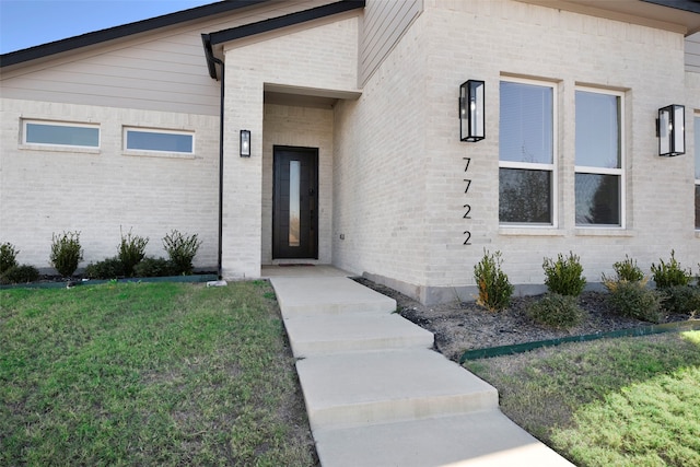 property entrance with a lawn