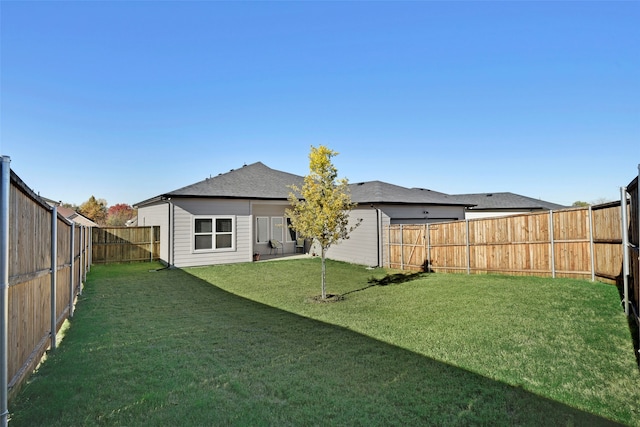 rear view of property featuring a yard