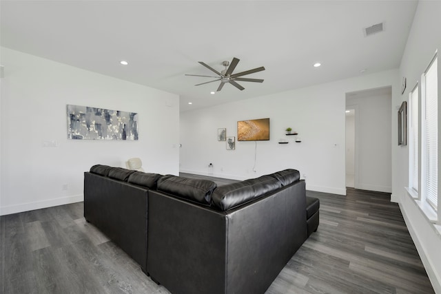 living room featuring ceiling fan and dark hardwood / wood-style floors