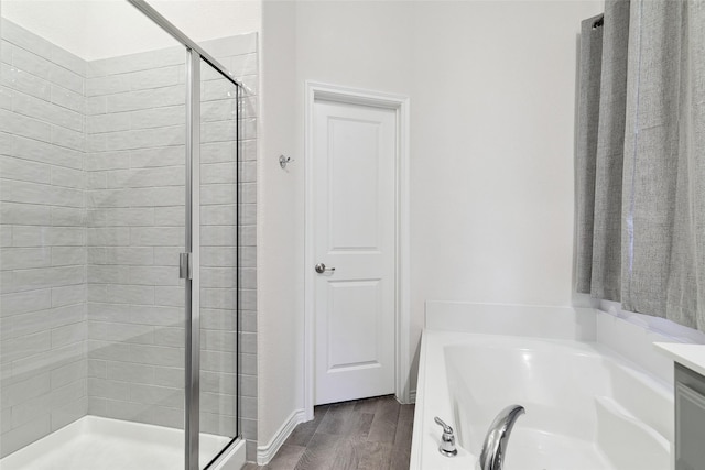 bathroom featuring plus walk in shower, hardwood / wood-style floors, and vanity