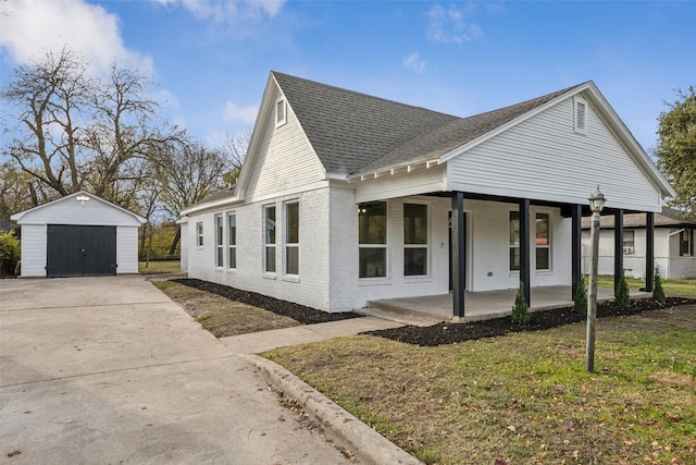 view of home's exterior with an outbuilding, a porch, a yard, and a garage