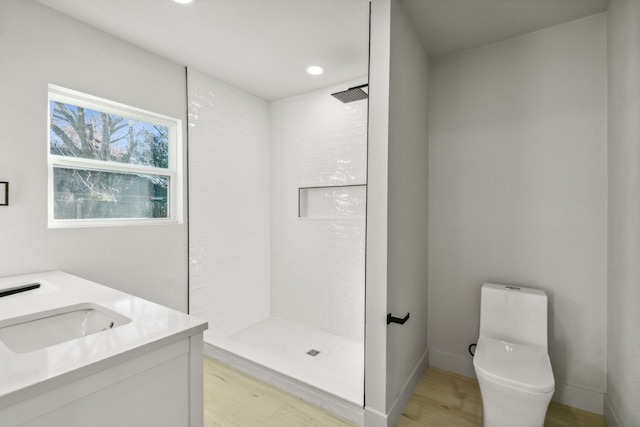 bathroom with vanity, toilet, wood-type flooring, and a shower