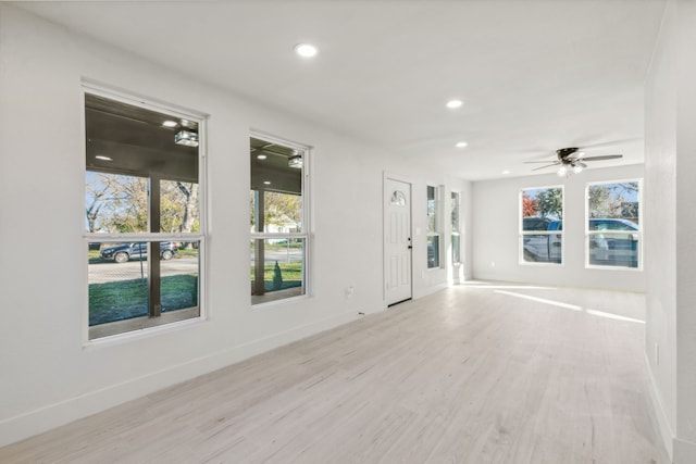 unfurnished room with light hardwood / wood-style flooring, plenty of natural light, and ceiling fan