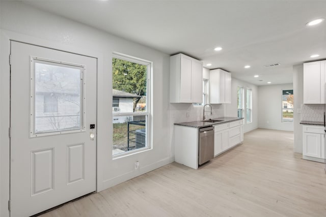 kitchen with decorative backsplash, white cabinetry, and a wealth of natural light