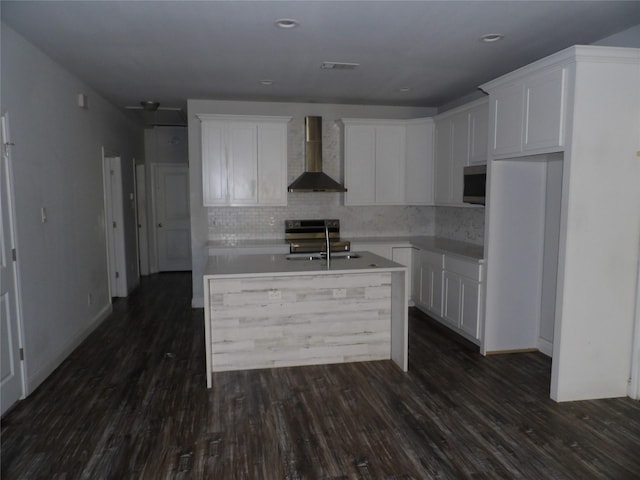 kitchen featuring sink, white cabinets, dark hardwood / wood-style flooring, a kitchen island with sink, and wall chimney exhaust hood