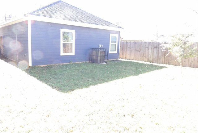 back of house with central AC and a yard