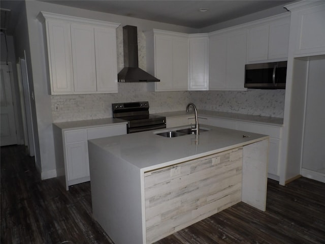 kitchen featuring wall chimney exhaust hood, sink, white cabinetry, a center island with sink, and electric range