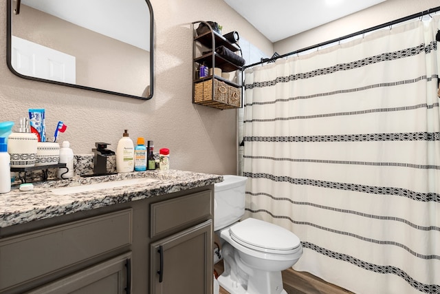 bathroom with hardwood / wood-style floors, vanity, and toilet