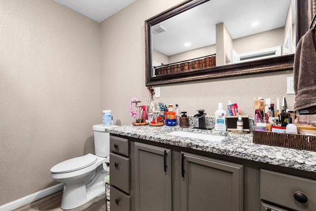 bathroom with hardwood / wood-style floors, vanity, a shower with shower curtain, and toilet