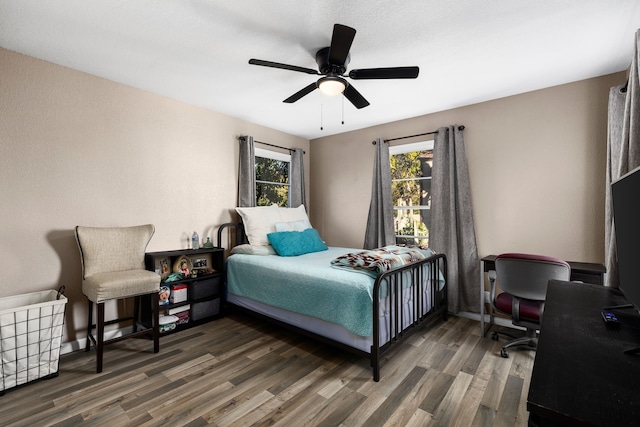 bedroom featuring dark hardwood / wood-style floors, multiple windows, and ceiling fan