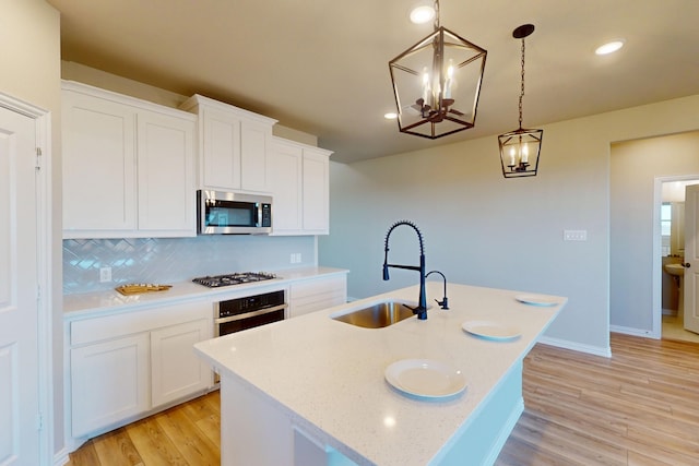 5000 Greenbrook Rd, Denton, TX 76226 - kitchen featuring stainless steel appliances, a sink, light wood finished floors, a chandelier, and backsplash