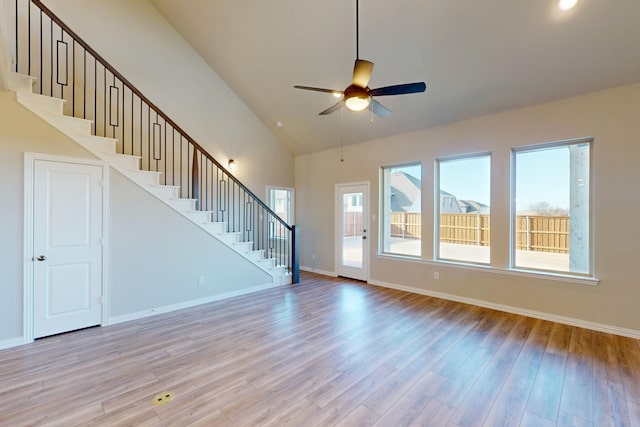 5000 Greenbrook Rd, Denton, TX 76226 - unfurnished living room featuring ceiling fan, stairway, light wood-style floors, healthy amount of natural light, and high vaulted ceiling