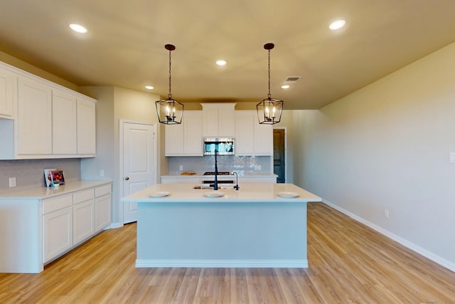 5000 Greenbrook Rd, Denton, TX 76226 - kitchen with stainless steel microwave, decorative backsplash, light countertops, light wood-style floors, and recessed lighting