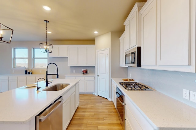 5000 Greenbrook Rd, Denton, TX 76226 - kitchen featuring appliances with stainless steel finishes, a sink, light wood-type flooring, white cabinets, and recessed lighting